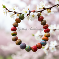 Multi-coloured beaded bracelet on a branch with white flowers, 'Spring Awakening' text.