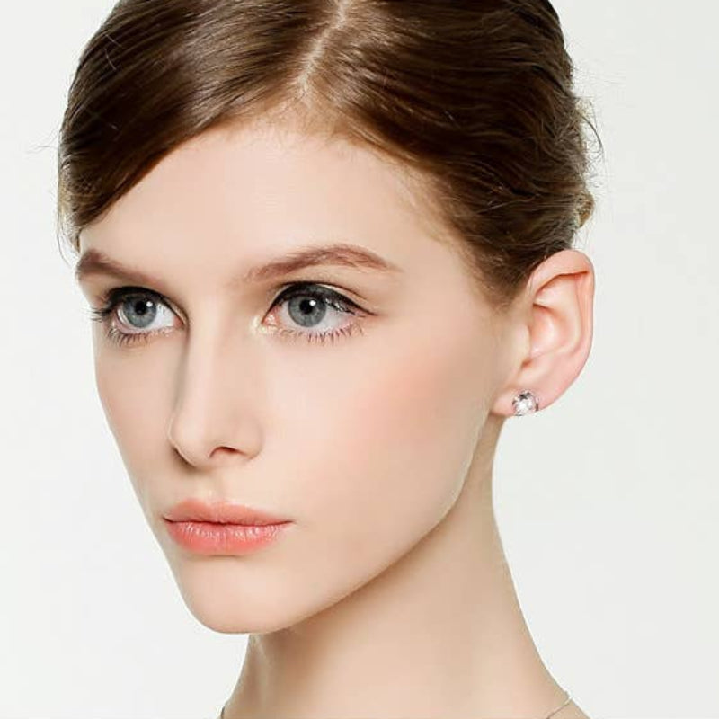 Close-up of a woman wearing a silver earring on a white background