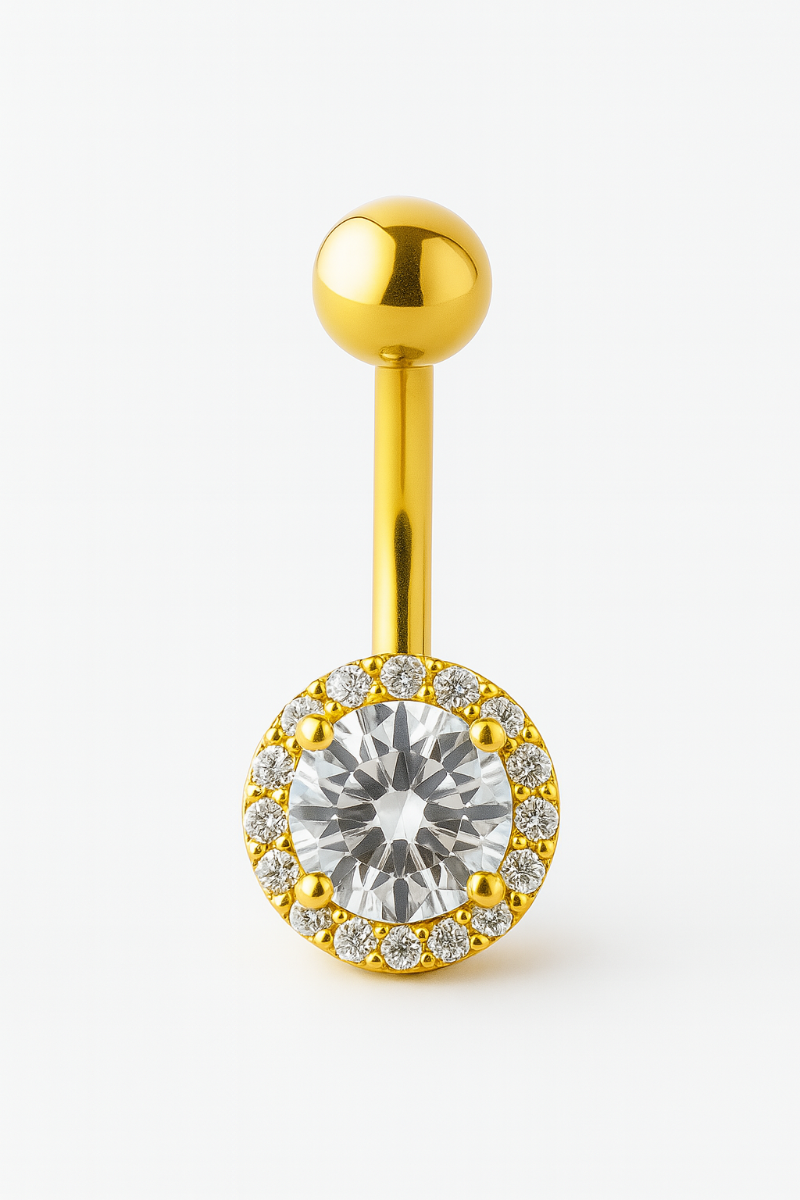 Gold belly button ring with a large central gemstone on a white background