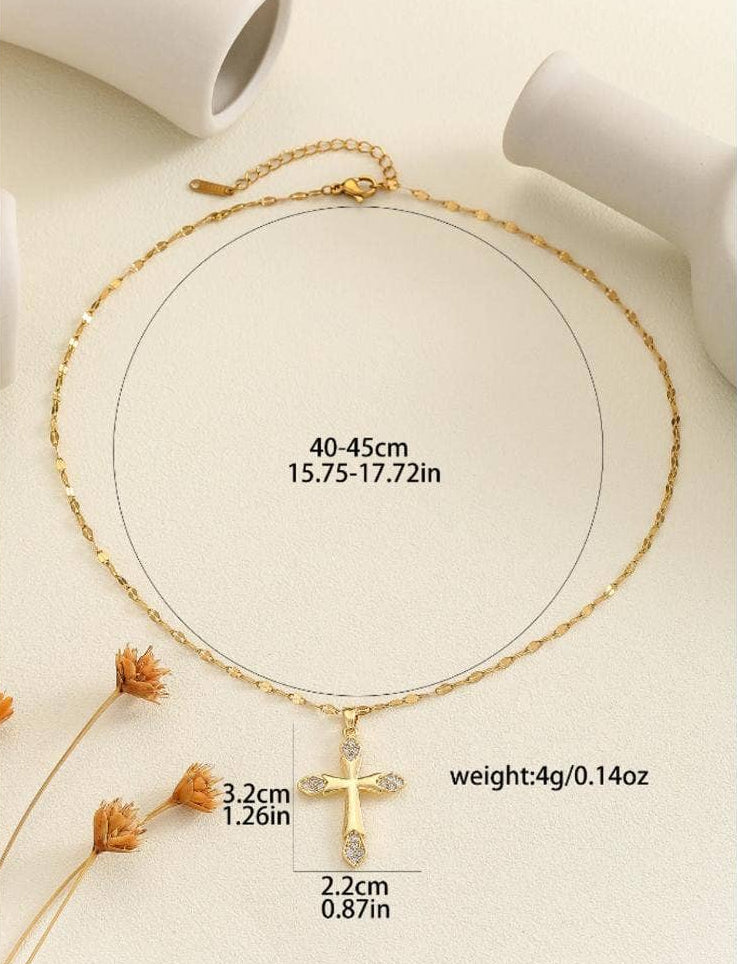 Gold necklace with cross pendant on a beige background
