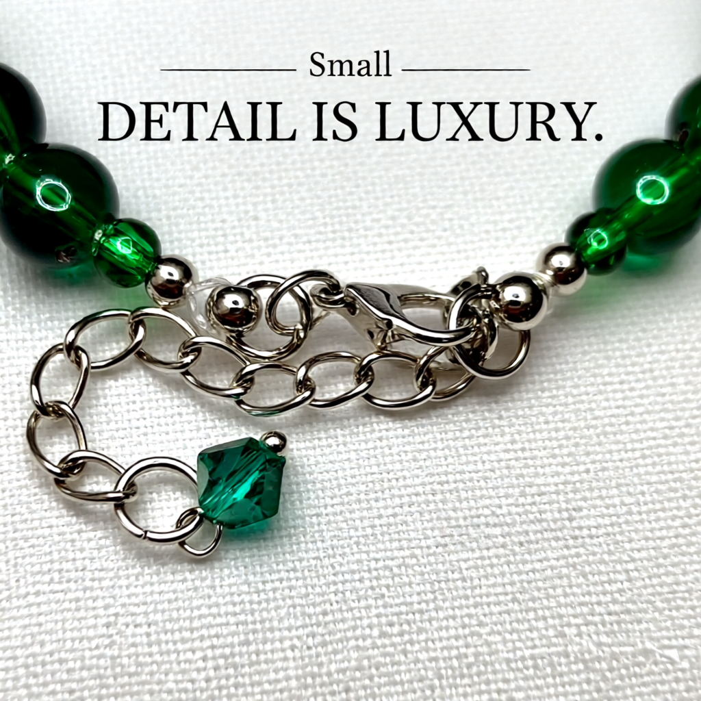 Bracelet with green beads and chain on a white background, featuring the text 'Small Detail is Luxury'.