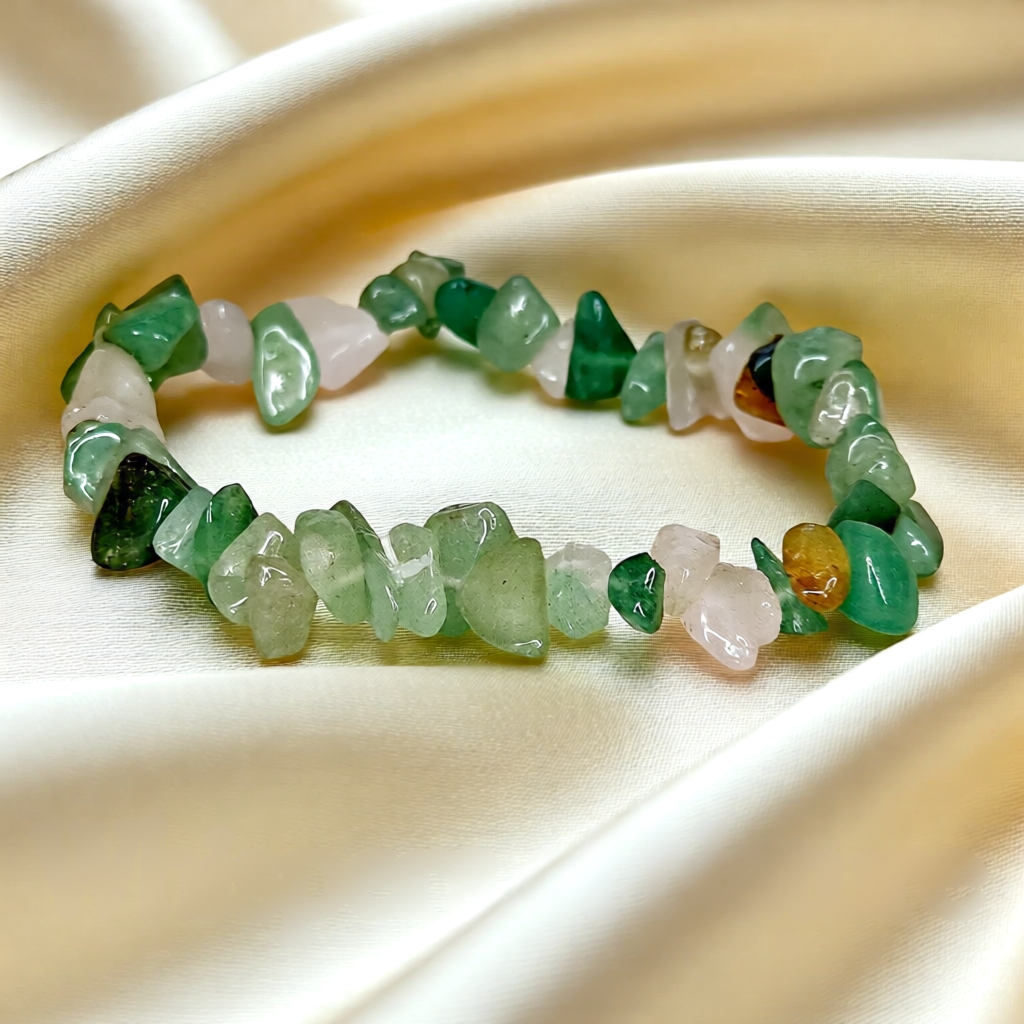 Stylish bracelet with green and pink stones on a beige fabric background