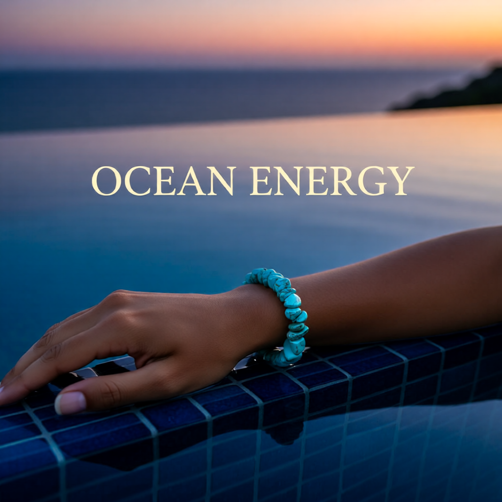 Hand with a turquoise bracelet by a pool at sunset with 'OCEAN ENERGY' text.