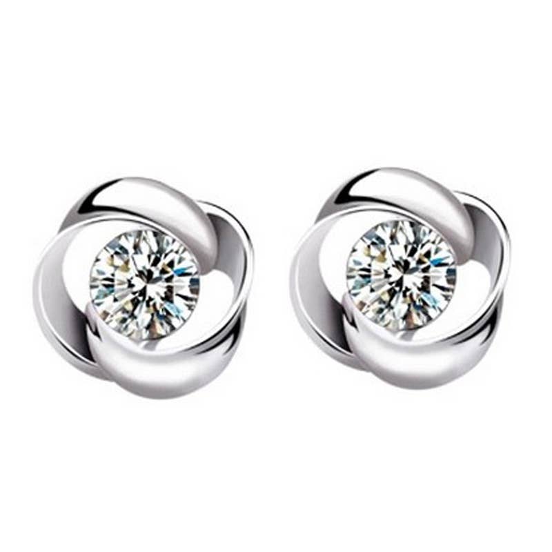 Pair of silver earrings with clear gemstones on a white background