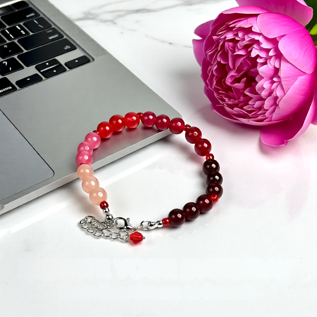 Beaded bracelet on a laptop with a pink flower