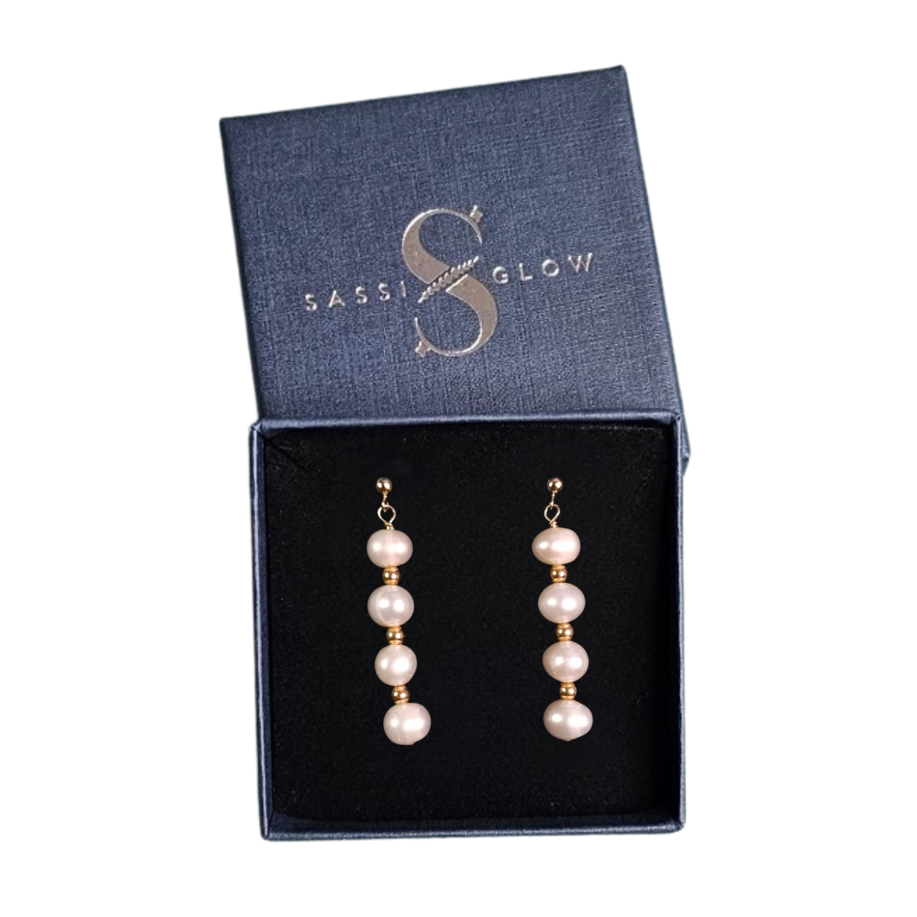 Pearl earrings in a 'Sassglow' box on a white background