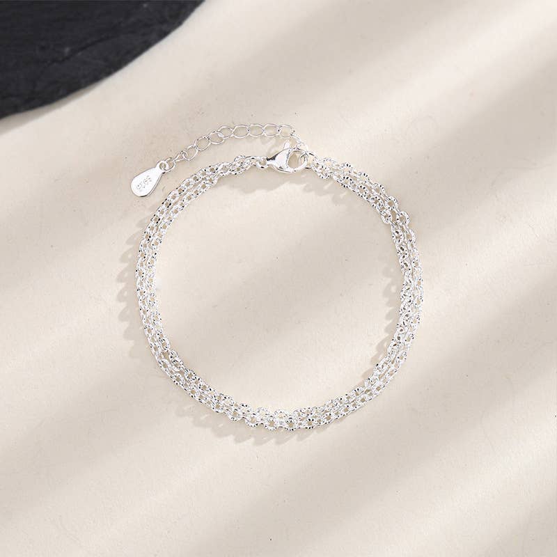 Silver bracelet on a plain background
