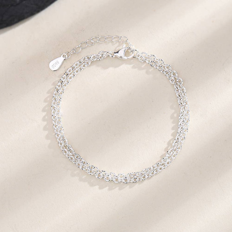 Silver bracelet on a plain background