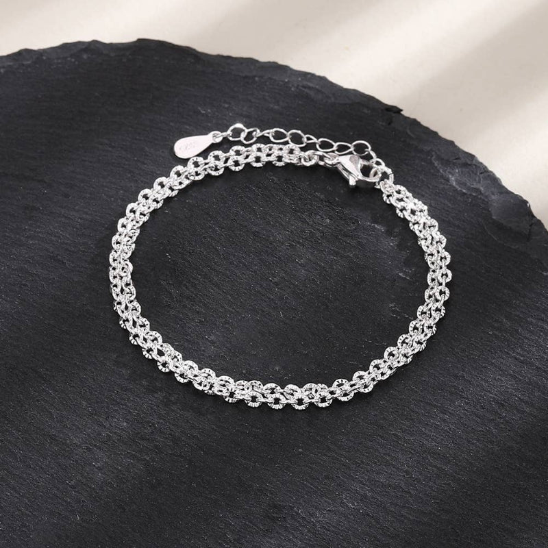 Silver bracelet on a dark stone surface
