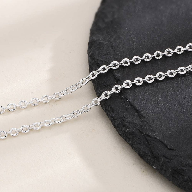 Silver chain necklace on a black stone surface